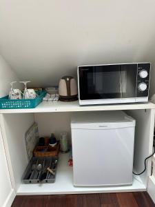 a microwave sitting on top of a shelf at Jacuzzi Apartment - Center Zagreb in Zagreb