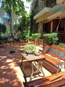 a patio with a wooden bench and a table at Papadioti Apartments in Pefki