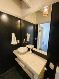 baño con 2 lavabos y espejo grande en Nordestina Loft, en Icaraí