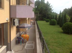 Un balcón con una sombrilla y una mesa y sillas. en Apartments Vicente, en Golden Sands