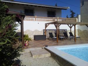 une terrasse avec une piscine et une maison dans l'établissement Casa rural CAÑADA PAEZ, à Vélez-Málaga