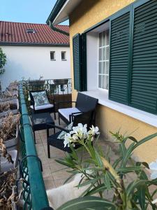 een patio met zwarte stoelen en witte bloemen naast een gebouw bij Maison Lyon-Bron Eurexpo - Stadium Groupama in Bron