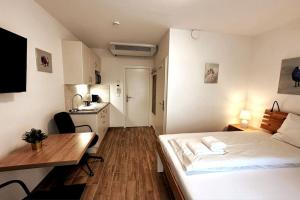 1 dormitorio con cama, escritorio y cocina en AJO Vetmed en Viena