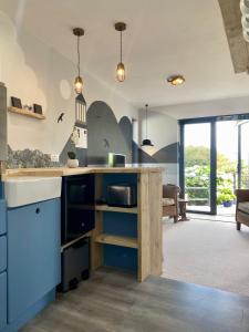 a kitchen with blue cabinets and a counter top at Mevagissey Boutique Flatlet with sea and countryside views in Mevagissey