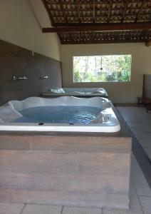 uma banheira de hidromassagem no meio de um quarto em Aldeia das Aguas Village em Barra do Piraí