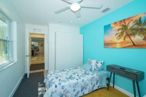 una camera da letto con una parete blu, un letto e un tavolo di Modern, Fresh - Only 3 miles to the Beach! a Sarasota