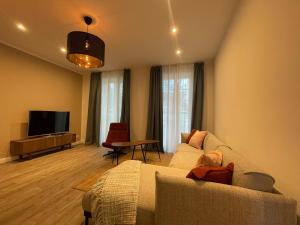 ein Wohnzimmer mit einem Sofa und einem TV in der Unterkunft Pension Luisengrün in Chemnitz