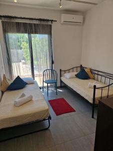 2 łóżka w pokoju z oknem i czerwonym dywanem w obiekcie Villa Marina w mieście Dhrámia