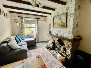 uma sala de estar com um sofá e uma lareira em May Rose Cottage em Sigglesthorne