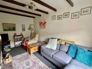 a living room with a couch and a table at May Rose Cottage in Sigglesthorne