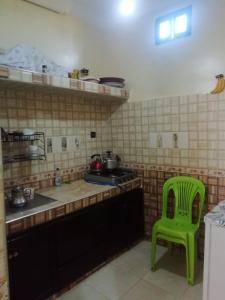 uma cozinha com uma cadeira verde e um fogão em شقة بجنب مطار المسيرة 