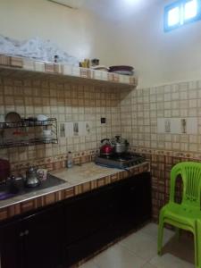 a kitchen with a stove and a green chair at شقة بجنب مطار المسيرة 