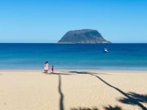 a woman and a child standing on a beach at Mitsio Paradise - Hotel privatif en pension complète in Nosy Mitsio