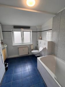 a bathroom with a tub and a toilet and a sink at Hotel Wandsbek Hamburg in Hamburg