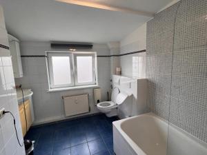 a bathroom with a toilet and a tub and a sink at Hotel Wandsbek Hamburg in Hamburg