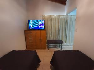 1 dormitorio con 2 camas y un tocador con TV en Monseñor Fagnano 592 "D" en Ushuaia