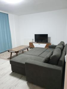 Budget Stay Guest House في Kosovo Polje: غرفة معيشة مع أريكة وطاولة