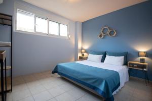 a blue bedroom with a large bed and two windows at Maisonette PT in Perea