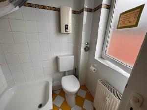 La salle de bains est pourvue de toilettes, d'un lavabo et d'une baignoire. dans l'établissement Hotel Wandsbek Hamburg, à Hambourg