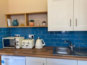 a kitchen counter with a sink and blue tiles at Church View House in Kells