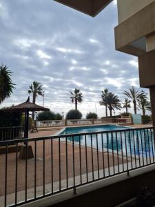 a swimming pool with palm trees in the background at FirstLine BeachView in El Campello