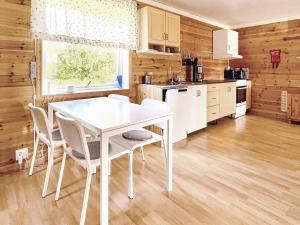 a kitchen with a white table and white chairs at Holiday home GUSTAVSFORS in Gustavsfors
