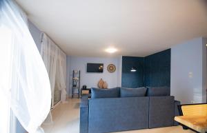 sala de estar con sofá azul en Maisonette PT en Perea