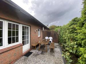 een patio met een tafel en stoelen naast een gebouw bij Holiday home Renate, Nessmersiel in Neßmersiel