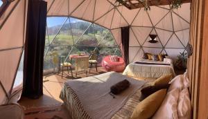 a room with two beds and a large window at Poas Volcano Observatory Lodge & Glamping in Poasito