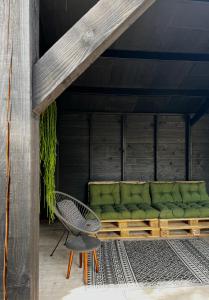 un sofá verde y una silla en el patio en Bijzonder Lekker overnachten, en Beetsterzwaag