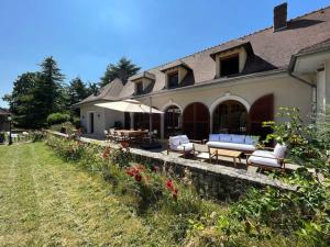 ein Haus mit Stühlen und Tischen davor in der Unterkunft Belle demeure de 500m2 avec 6 chambres in Auffreville-Brasseuil