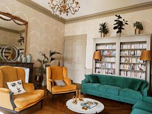 a living room with a green couch and chairs at Le 1825, une suite luxueuse au coeur de la ville in Nantes