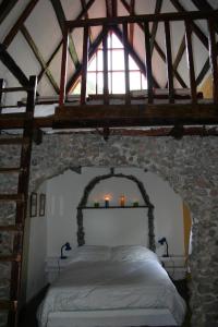 Un dormitorio con una cama en una pared de piedra. en Top Of The Mountain - The Eagles Nest, en Las Nubes