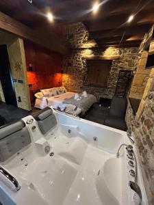 a large bath tub in a room with a bedroom at La Tentacion de Mazobre - La Suite de la Montaña Palentina in Alba de los Cardaños