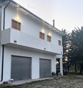 ein weißes Haus mit zwei Garagentüren darauf in der Unterkunft Country House Nora Rech in SantʼElpidio a Mare