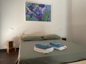 a bed with towels on it with a painting on the wall at Country House Nora Rech in SantʼElpidio a Mare