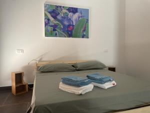 ein Bett mit Handtüchern drauf mit einem Gemälde an der Wand in der Unterkunft Country House Nora Rech in SantʼElpidio a Mare