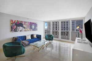 a living room with a blue couch and two green chairs at Wildest Dreams Penthouse! Dreams Do Come True in Miami