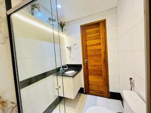 a bathroom with a toilet and a glass shower at Praia Dourada in Vila Velha