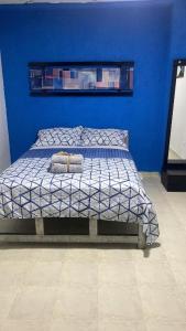 1 dormitorio azul con 1 cama con pared azul en Hostal Cigarra en Panamá
