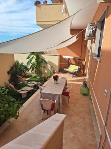 patio con tavolo, sedie e ombrellone di DOMUS 0143 a San Giorgio Ionico