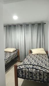 2 Einzelbetten in einem Zimmer mit Vorhang in der Unterkunft Idiliz in Borj