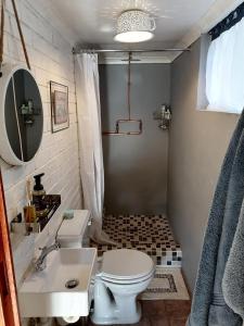 ein Badezimmer mit einer weißen Toilette und einem Waschbecken in der Unterkunft Collie Cottage in Clarens