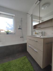 a bathroom with a sink and a tub and a window at Ferienwohnung Großalber in Maria Neustift