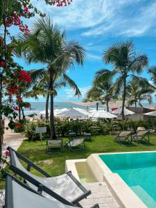 a resort with a swimming pool and palm trees at Nordestina Loft in Icaraí