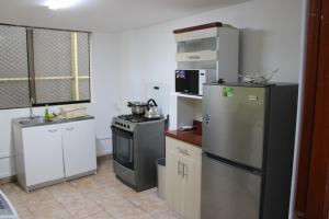 a small kitchen with a refrigerator and a stove at Hospedaje San Isidro 402 in Lima