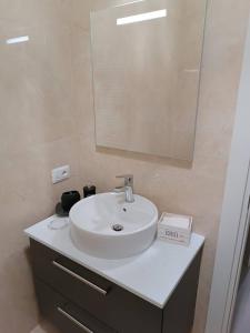 ein Badezimmer mit einem weißen Waschbecken und einem Spiegel in der Unterkunft Pirelli 28 in Mailand