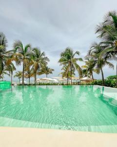 una gran piscina con palmeras en el fondo en Nordestina Loft, en Icaraí