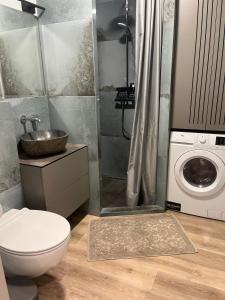 La salle de bains est pourvue de toilettes et d'un lave-linge. dans l'établissement Obelų namai, self check-in, free parking, à Klaipėda