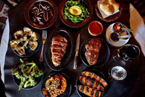 Una mesa con muchos platos de comida encima. en Luciana Palermo Soho, en Buenos Aires